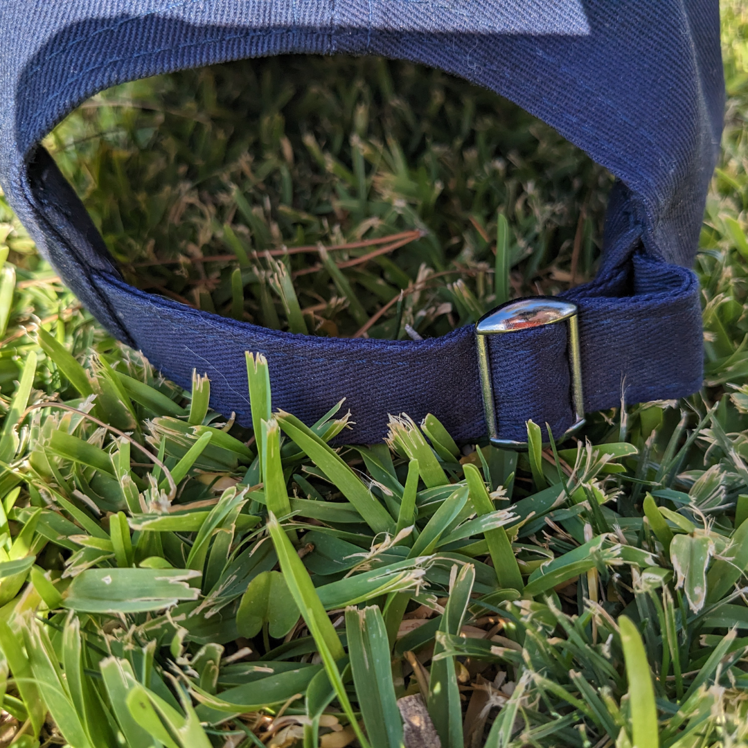 Back of hat, showing strap with silver clip for adjusting size.
